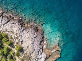 Vista aérea de buceador en solitario en aguas turquesas costeras verdes