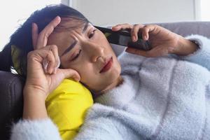 Woman lying on the couch at home with anxious facial expression photo