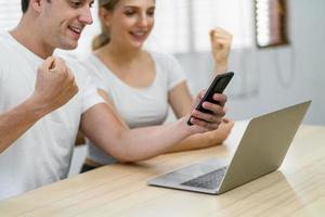 Una joven pareja caucásica utilizando tecnología en casa foto