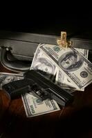 Arma y billete de un dólar en maletín.