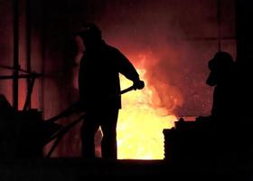 Man working in the splashing molten iron - Stock Image photo