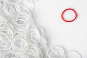 One red rubber ring among multitude white rings