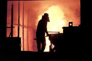 Man working in the splashing molten iron - Stock Image photo