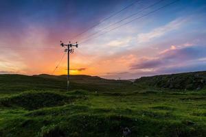 Telephone or electricity line in the fields at sunset