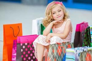 Little girl with shopping bags goes to the store