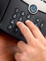 hand dialing number on black landline phone