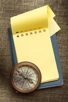 Vintage compass and blank yellow notepad photo