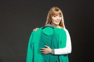 Fashionable woman holding green coat photo