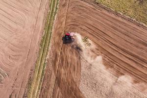 aerial view of  of tractor on harvest field photo