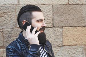 atractivo hombre barbudo hablando por teléfono foto