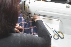 Mujer cosiendo en una máquina de coser.