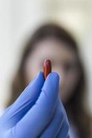 Doctor holding red pill capsule photo