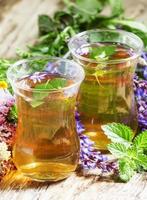Green hot tea with herbs in Islamic glasses