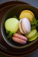 Colorful macaroons on brown plate photo