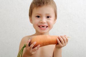 niño sin dientes con zanahoria grande