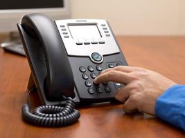 person dialing number on landline photo