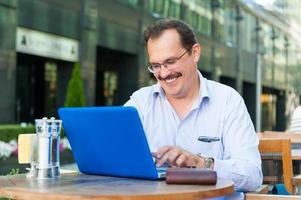 Middle age businessman works on laptop