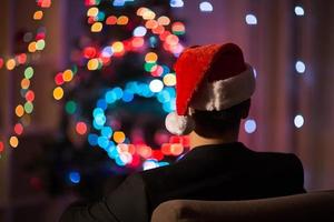 Man in santa's hat sitting in chair photo