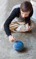 Attractive boy with Autism Spins a Ball