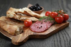 antipasti con salami, aceitunas, tomates y pan