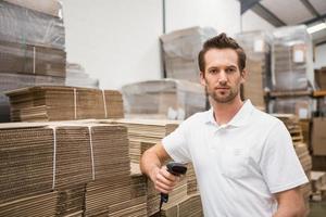 Serious warehouse worker holding scanner