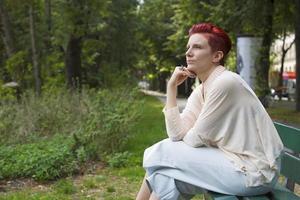 red-haired sitting on a bench photo