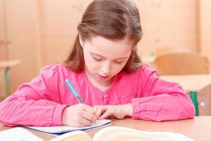 Little writing girl during classes photo