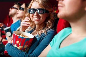 Woman in 3 d glasses eating popcorn photo