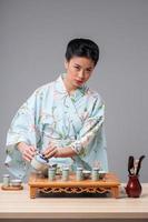 belleza asiática preparándose para la ceremonia del té