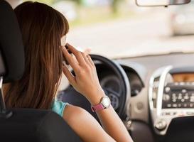 woman using phone while driving the car photo