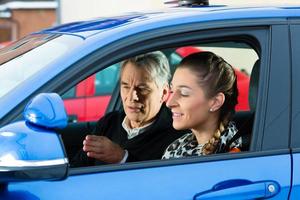 Young woman taking instructions from her driving instructor photo