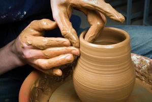 manos de un alfarero, creando una jarra de barro