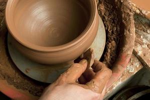manos de un alfarero, creando una jarra de barro