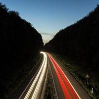 Car light trails on highway at sunset