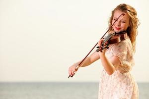 la chica rubia con un violín al aire libre