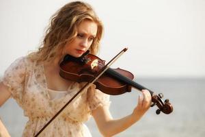 Retrato chica rubia con un violín al aire libre foto
