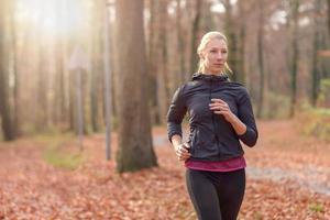 Pretty fit young woman jogging in woodland