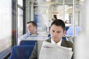 empresario leyendo periódico en tren foto