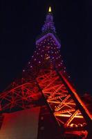 Tokyo Tower lit up with colourful lights at night photo