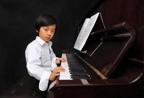 Young Asian boy playing piano photo