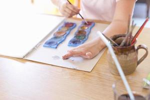 Girl finger-painting with watercolors photo