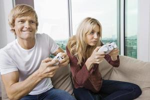 Young couple playing video game in living room photo