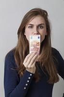 suspiscious young girl smelling a bill for dirty money laundering