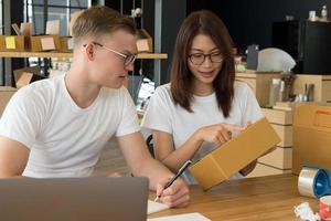 startup small business owner working at workplace. freelance man & woman seller check product order for delivery.  Online selling, e-commerce, shipping concept photo
