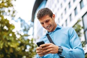 Young businessman online via smartphone in the city