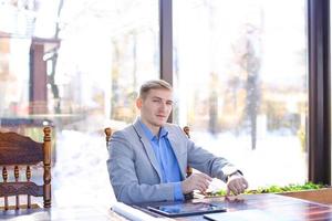 Interior designer sitting at cafe, using smart watch near roll p photo