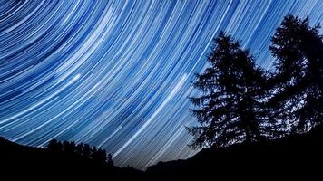 Star trail. Night sky over mountain forest. photo