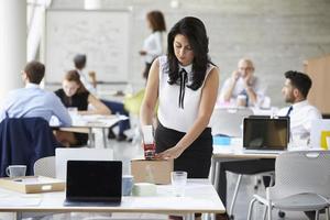 Businesswoman In Office Preparing Package For Shipping