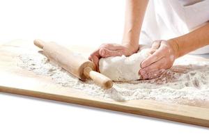 hands kneading dough on  board photo