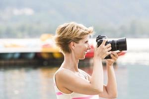 Young woman takes a picture with her DSLR photo